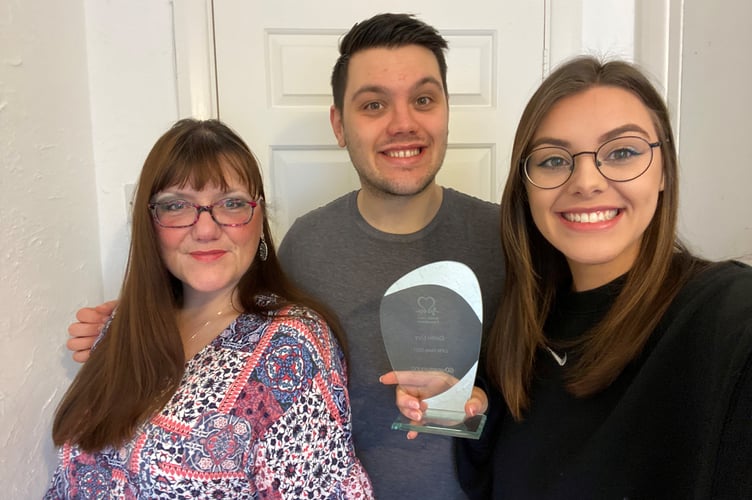 Caitlin is pictured holding her Heart Hero Award with her brother Matthew Lory and mother Hayley Small