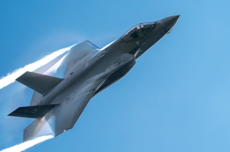 Heart-stopping picture taken by Tom Pennington shows plane spotter's hat getting blown off his head as fighter jet roars overhead.  See SWNS story SWSMjet.  This is the moment a plane spotter missed his shot when his hat was blown off by a low-flying F-35 fighter jet.  Tom Pennington, 50, captured the hilarious âone-in-a-millionâ snap while photographing the RAFâs low-level training exercise in North Wales.  The F-35 â which has a dizzying top speed of 1,200mph â roared overheard taking a group of plane spotters by surprise.  Ambulance technician Tom pictured the scene during the military exercise on May 12. 