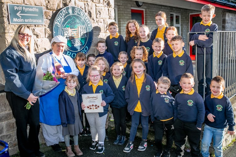 Harlech Foodservice
Ysgol y Gorlan, Tremadog
Much loved dinner lady Rhian Parry is retiring after 35 years serving up delicious lunches at the school.
Ursula Scurrah-Price, former pupil, and now in charge of deliveries to Gwynedd schools presents Rhian Parry with some thnak you gifts to wish her well on her retiremet. They  are joined by pupils wishing her a happy retirement