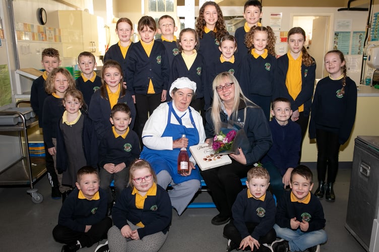 Harlech Foodservice
Ysgol y Gorlan, Tremadog
Much loved dinner lady Rhian Parry is retiring after 35 years serving up delicious lunches at the school.
Ursula Scurrah-Price, former pupil, and now in charge of deliveries to Gwynedd schools presents Rhian Parry with some thnak you gifts to wish her well on her retiremet. They  are joined by pupils wishing her a happy retirement