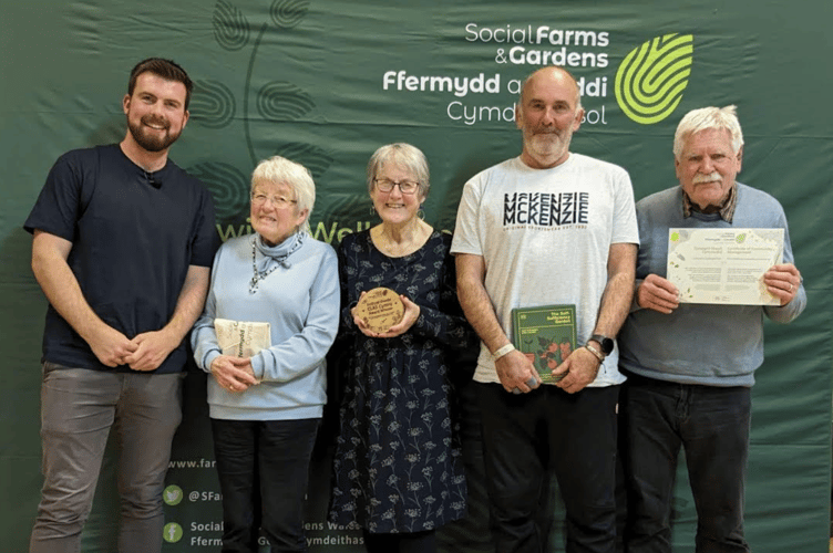 Members of the Y Tir team receive their award from gardener, author and YouTube influencer, Huw Richards