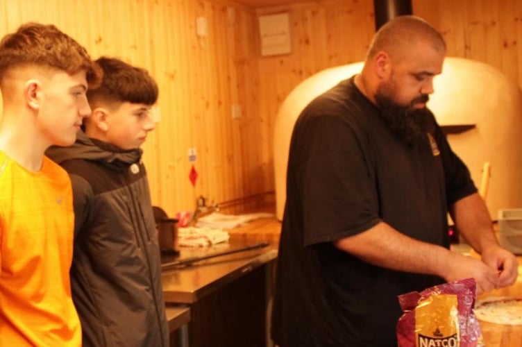 Pizza masterclass by Chris “Flamebaster” Roberts, watched by Noa Hughes and Jac Roberts. Photo: Cian Roberts