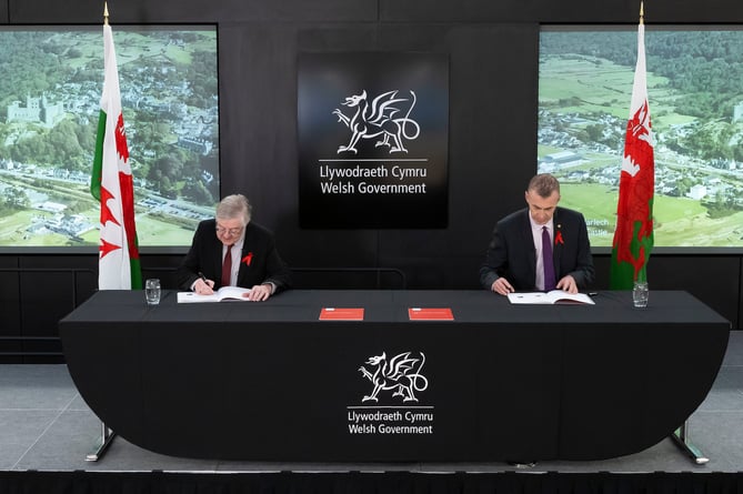 Former first minister of Wales Mark Drakeford and former leader of Plaid Cymru Adam Price sign the Co-operation Agreement at the Welsh Government in 2021