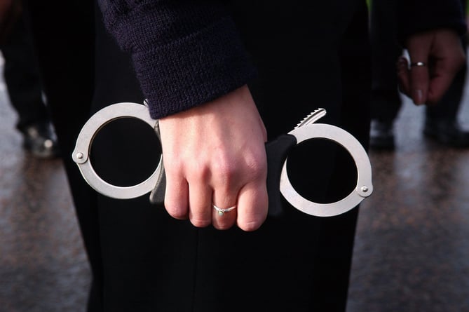 A police recruit at Hendon Police training centre in North London grips a pair of handcuffs. The recruits handcuffed themselves together in order to break the world record for the most people handcuffed together for charity.