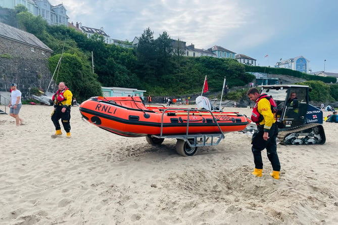 New Quay RNLI's lifeboat returns to the station with helm Dylan Price, left, and crew, Huw Williams, right. Photo: RNLI