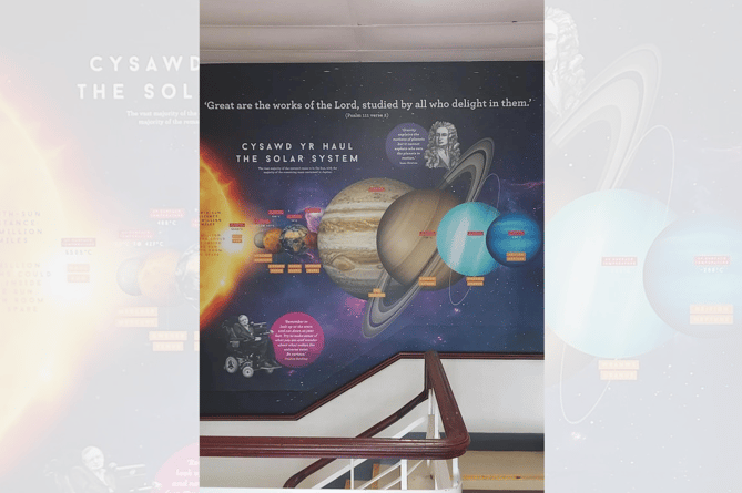 The poster at the top of the stairs describes the solar system as 'Great are the works of the Lord, studied by all who delight in them'.