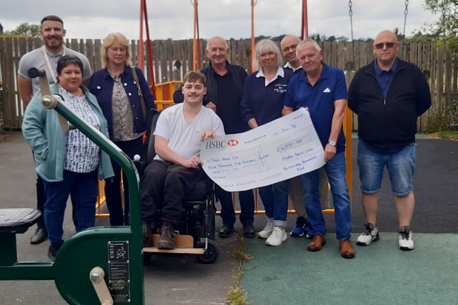 Left to right: Mr Brunelli, Gwen Evans (Jammy Dodger), Jackie Thomas (Jammy Dodger), Nigel Beattie, Lynne Gilbertson, Jerry Gilbertson (men's captain MYC Rowing), Mike Morris and Rob Murray presenting the cheque to pupil Lewis Walker (centre) 