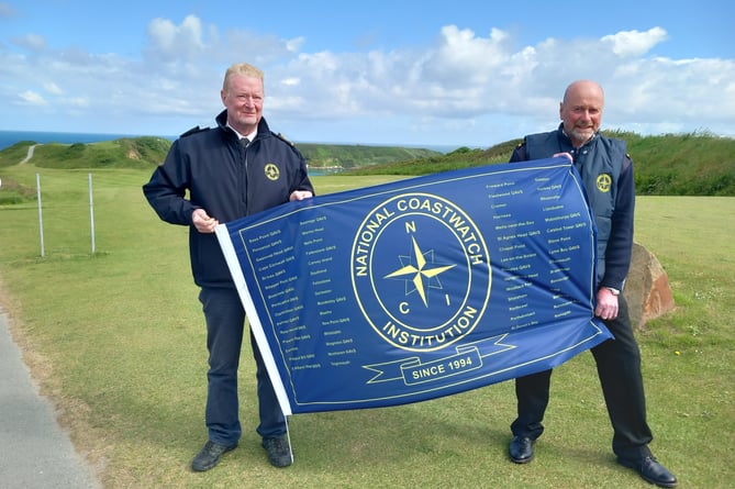 Picture of Station managers Andy, from Porthdinllaen, on the left, and Trevor, from Rhoscolyn, on the right, with the NCI’s 30th anniversary flag