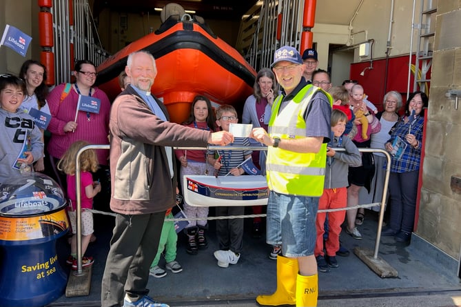 Penrhyndeudraeth’s Holy Trinity Church Saturday Club members donate £70 to the RNLI. Reverend Roland Barnes is pictured here presenting a cheque to Archdeacon Robert Townsend, who is also a RNLI Lifeboat volunteer at Criccieth Lifeboat Station.