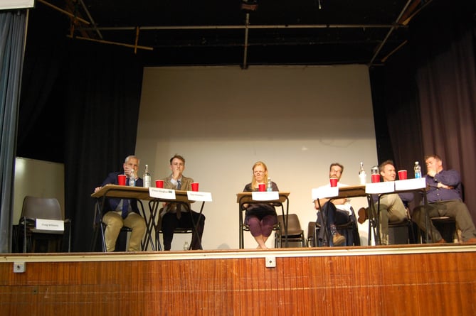 Craig Williams' empty seat was set aside as the other candidates waited to begin the husting