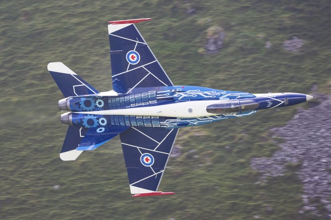 The Royal Canadian Air Force's (RCAF) CF-18 Hornet flies through the so-called Mach Loop in Wales, July 17 2024.   Jaw-dropping images show a warplane zooming through Wale's so-called Mach Loop on Wednesday (17 July). The Royal Canadian Air Force's (RCAF) CF-18 Hornet showed off its agility while it made its way to RAF Fairford as it prepares to display at the 2024 Royal International Air Tattoo. The pilot showing off his skills is Captain Caleb âTangoâ Robert, who serves as a combat-qualified element lead on the CF-18 for 425 (Alouettes) Tactical Fighter Squadron at 3 Wing in Quebec. The Mach Loop is a series of valleys in west-central Wales, notable for their use as low-level training areas for fast aircraft. The Loop is among the few places in the world where photographers can see combat aircraft flying below them.
