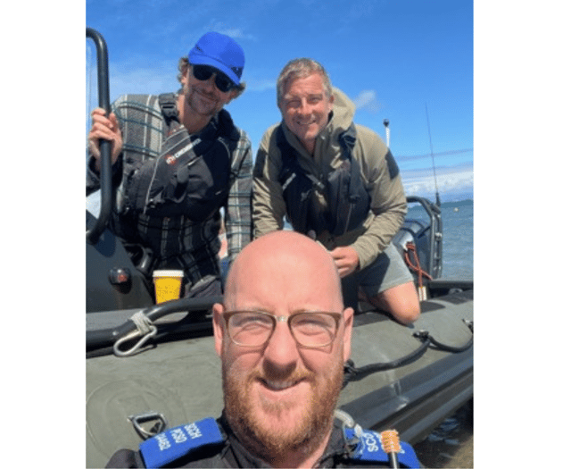 Gwynedd PCSO poses with screen stars Bradley Cooper and Bear Grylls