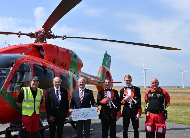 Members of The Royal Oakeley Silver Band present £2,500 to the Wales Air Ambulance charity