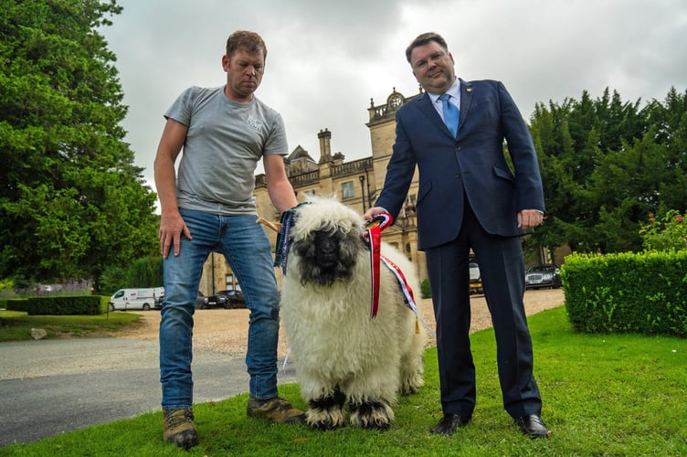 Palé Hall director Calum Milne (right) and farm manager Mark Tustain with Valais Blachnose female champion, Ayrshire Ingrid with the hall in the background