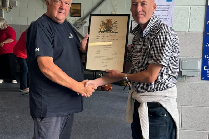 Jason Warren receives his certificate from Gerallt Williams, Pwllheli RNLI’s chair. Photo: RNLI/Caroline Jones