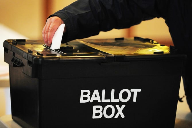 A voter places a ballot paper in the ballot box at the polling station at Market Hall in Swadlincote, Derbyshire, as the General Election got underway across the UK.