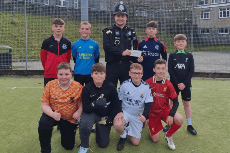 PC Williams of Blaenau Ffestiniog presents a cheque to Clwb Pel Droed Ieuenctid Blaenau Ffestiniog