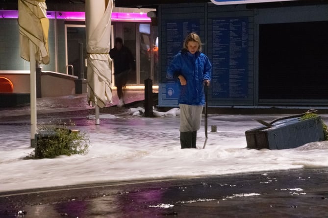 A volunteer wearing wellies whilst clearing drains by the Prom Diner in Aberystwyth