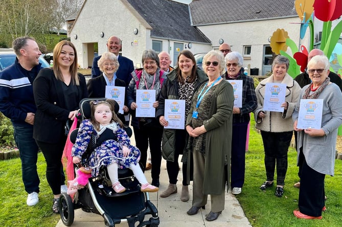 Llyn Peninsula Friends of Ty Gobaith group (with certificates) and the Hughes family whose daughter Matilda (front) attends the hospice in Conwy