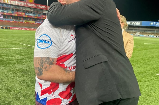 Steffan Rees’ father, Jamie Tank, gets a hug from one of Steffan’s former teammates