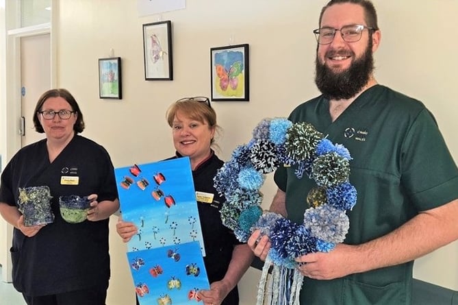 Hywel Dda staff with craftwork made by patients taking part in arts activities