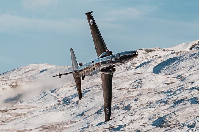 Hawk T2 advanced trainer aircraft flies through Mach Loop in Eryri National Park (Snowdonia) on November 21, 2024.    Jaw-dropping pictures show RAF airplanes zooming through a snowy Mach Loop in Wales on Thursday (21 Nov). An RAF Hawk T2 advanced trainer aircraft and an A400M transport aircraft were caught on camera by Sgt 'Matty' Matthews. The 84-ton A400M had already completed an airdrop over Salisbury Plains, flown over Scotland and the Lake District before passing through the Mach Loop and heading home to RAF Brize Norton in Oxfordshire. "Come rain or snow, RAF aircraft and their crews continue to operate whatever the weather," said the RAF, "In this case, with the snowy backdrop of the Eryri National Park behind them."
