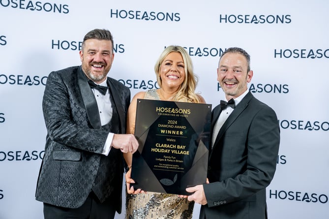 Thomas Scarrott, Co-owner and Finance Director at Vale Holiday Parks (L) - the parent company of Clarach Bay Holiday Village and Richard Brown, Senior Manager (R) receive the park’s award from Gemma Brown, General Manager at Hoseasons