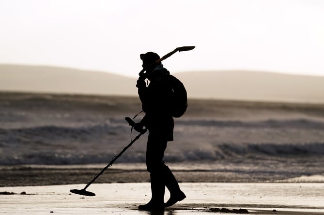 A metal detectorist on Bournemouth Beach, Dorset, as Storm Eunice sweeps across the UK after hitting the south coast earlier on Friday. With attractions closing, travel disruption and a major incident declared in some areas, people have been urged to stay indoors. Picture date: Friday February 18, 2022.