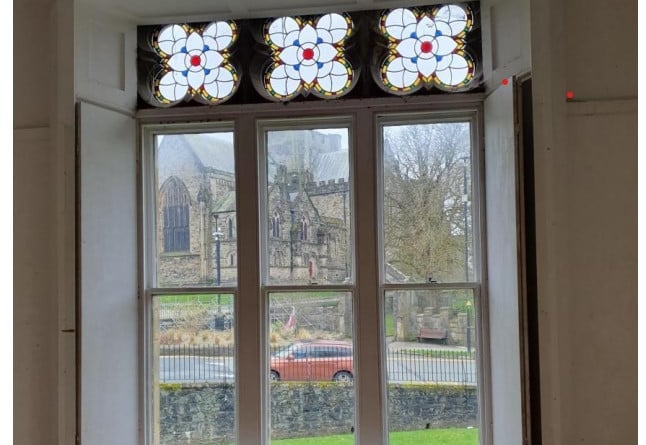 This photograph shows an attractive glass feature in the building and the view across to the cathedral. Photo: Gwynedd Council