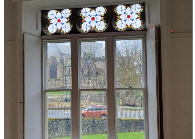 This photograph shows an attractive glass feature in the building and the view across to the cathedral. Photo: Gwynedd Council