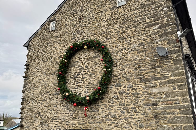 The homemade wreath on the side of Laura's house