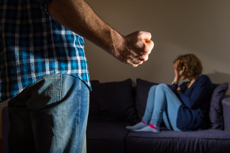 PICTURE POSED BY MODEL A man stands with a clenched fist as a woman cowers in the corner.