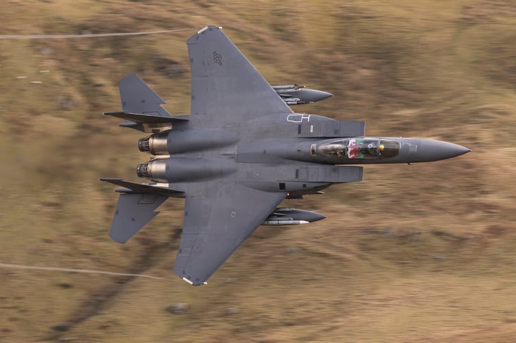 An F-15E Strike Eagle displays a Welsh flag as it flies the mach loop out of RAF Lakenheath. Photo released February 7 2025. The Mach Loop is a set of valleys in Wales near the town of Machynlleth from where it gets its name. The valleys are regularly used for low level flight training down to as low as 250 feet.