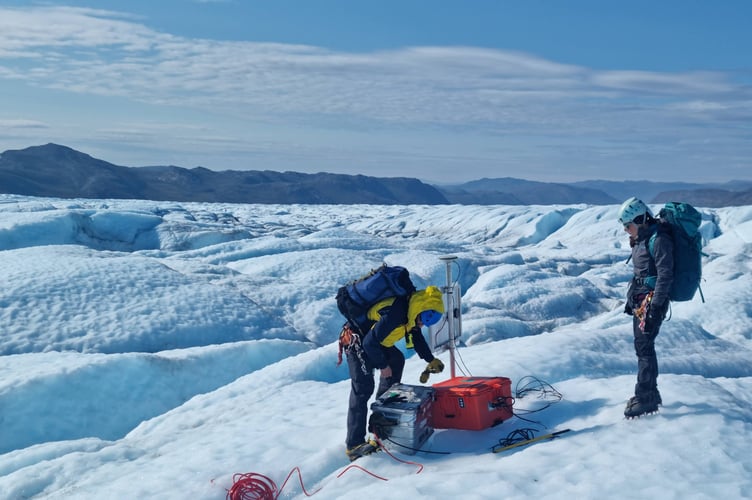 Dr Samuel Doyle (left) maintaining a seismometer on the Greenland Ice Sheet.